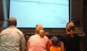 small family watching a big screen