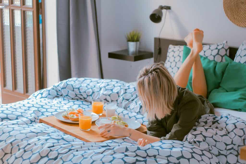 girl laying on the bed with breakfast