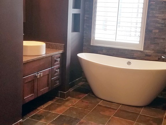 rustic slate bathroom with large tub and window