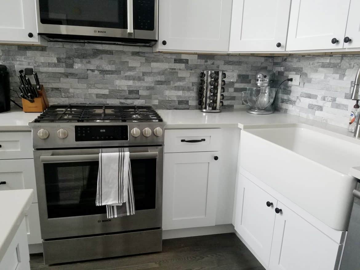 transitional white kitchen with grey subway backsplash