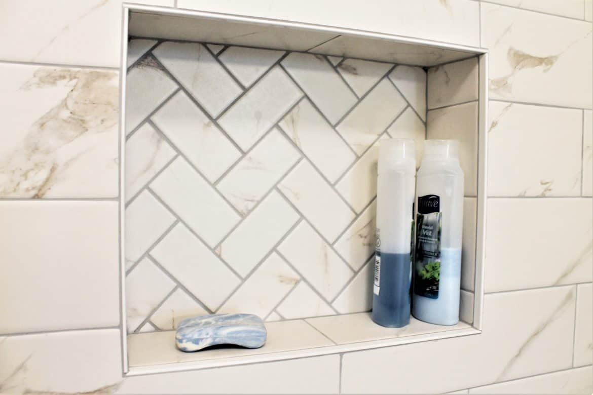 shower niche with white marble subway tiles and bullnose trim